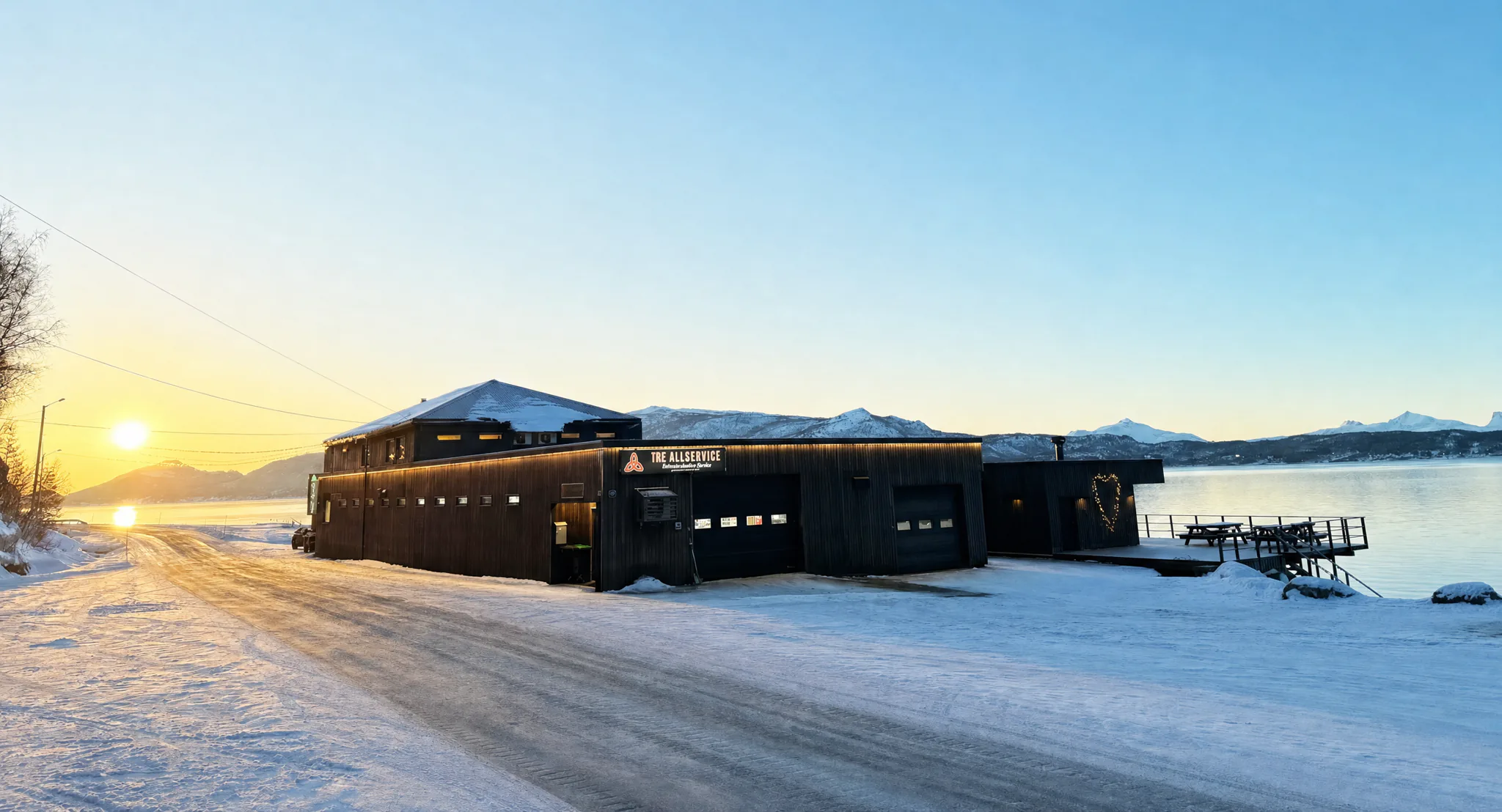 TRE Allservice sitt bygg i Brøstadbotn ved soloppgang om vinteren